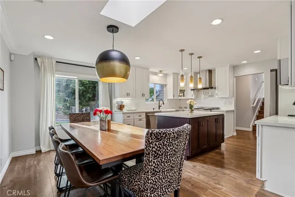 a kitchen with stainless steel appliances kitchen island granite countertop a stove a refrigerator a kitchen island a sink and a refrigerator