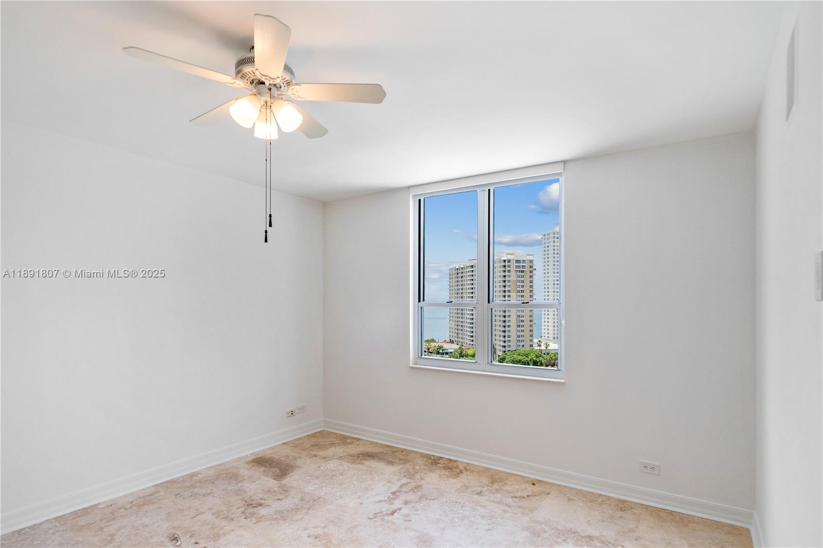 701 Brickell Key Boulevard, Unit 1411 Miami, FL 33131 - Photo 12 of 20 an empty room with window and chandelier fan
