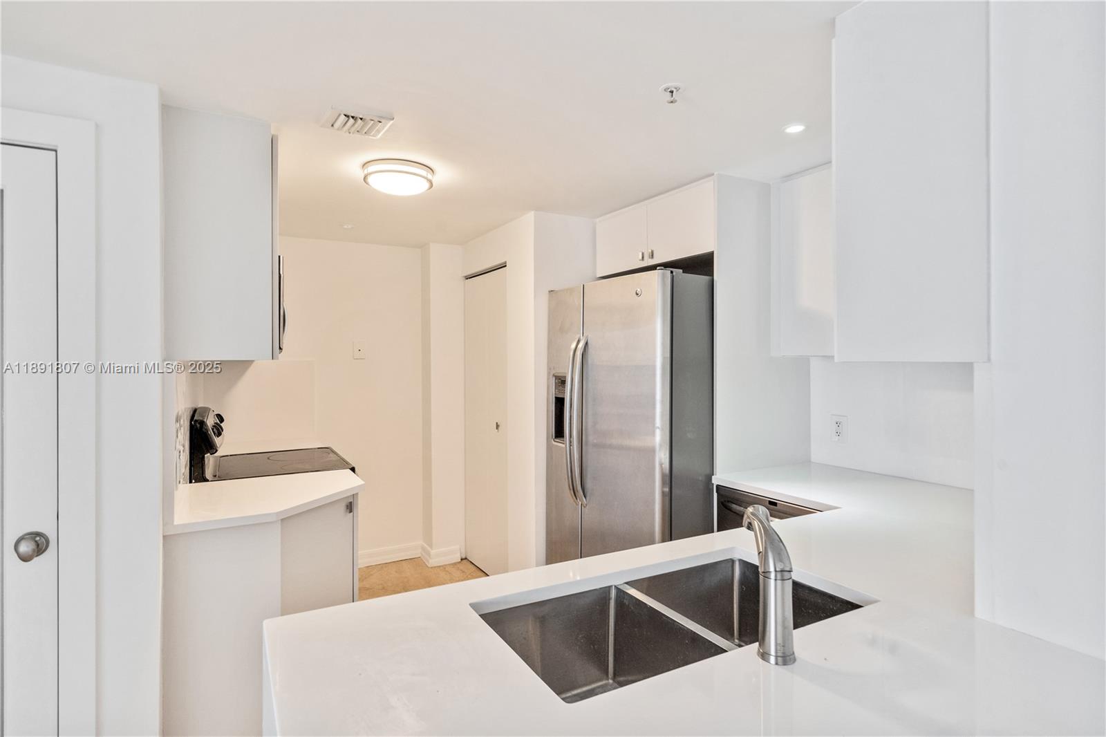 701 Brickell Key Boulevard, Unit 1411 Miami, FL 33131 - Photo 6 of 20 a kitchen with stainless steel appliances granite countertop a sink a stove and a refrigerator