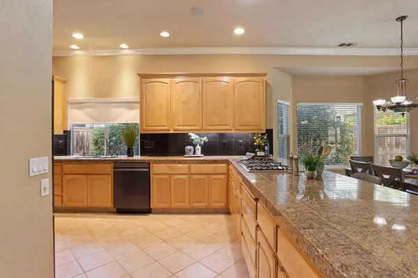 a kitchen with stainless steel appliances granite countertop a stove a sink and a microwave