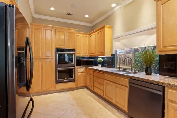 a kitchen with stainless steel appliances granite countertop a refrigerator and a stove top oven