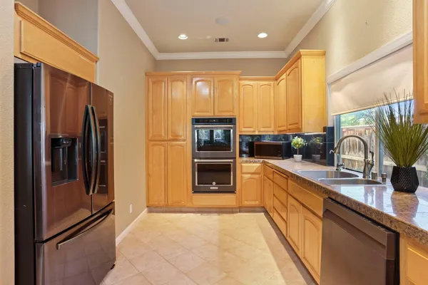 a kitchen with stainless steel appliances granite countertop a refrigerator and a sink