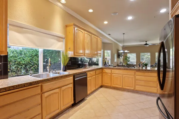 a large kitchen with kitchen island granite countertop a large window cabinets and stainless steel appliances