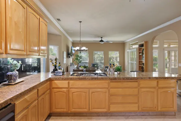 a large white kitchen with granite countertop a sink and white cabinets