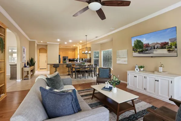 a living room with furniture kitchen view and a large window