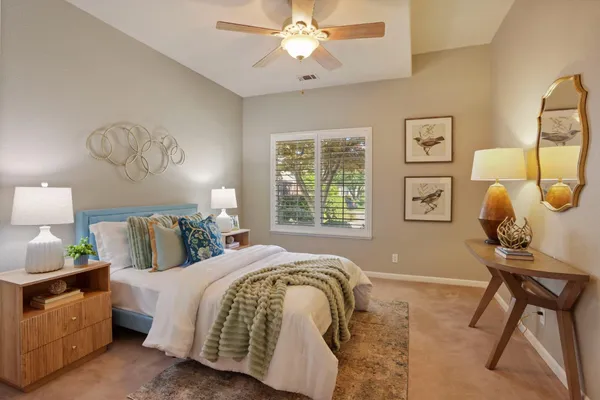 a spacious bedroom with a bed and a chandelier