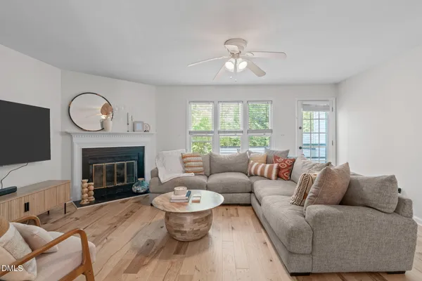 a living room with furniture a fireplace and a large window
