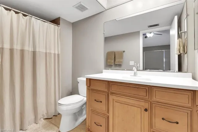 a bathroom with a toilet a sink and a large mirror
