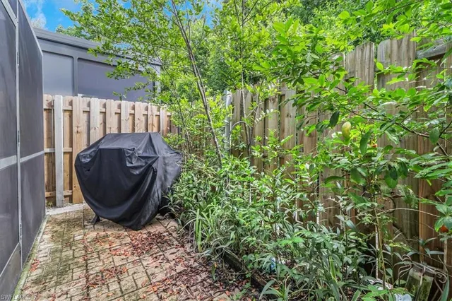 a view of a backyard with plants and a grill