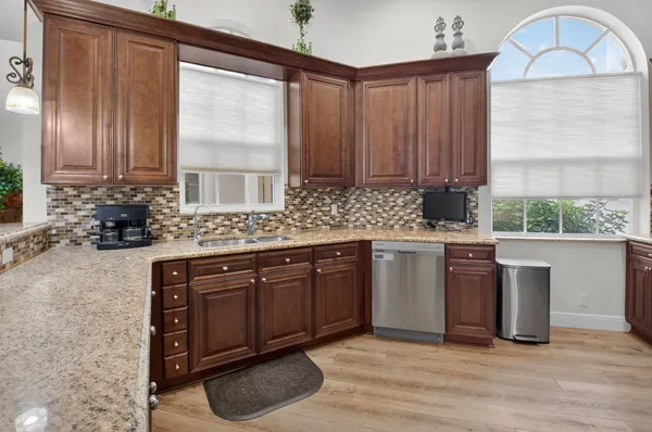 a kitchen with stainless steel appliances granite countertop a stove a sink and a microwave