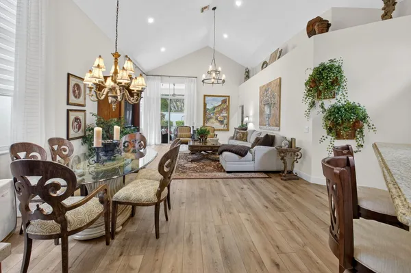 a living room with furniture a chandelier and a dining table