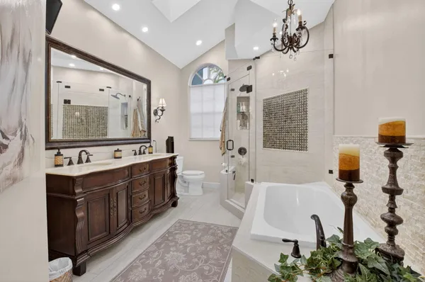 a spacious bathroom with a double vanity sink mirror and tub