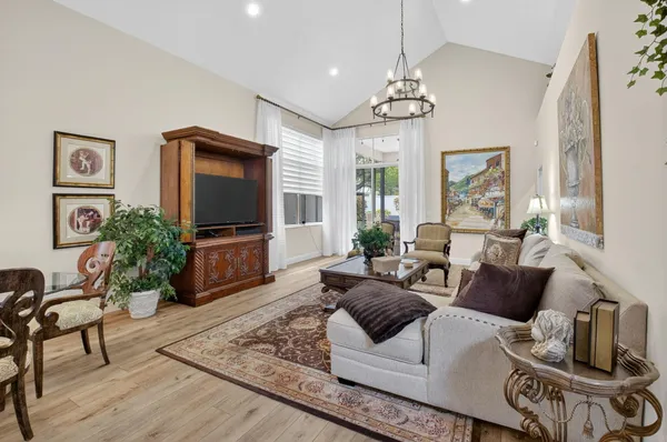 a living room with furniture a chandelier and a flat screen tv