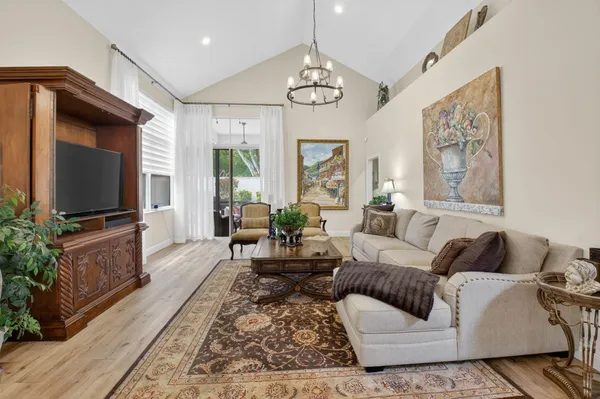 a living room with furniture a large window and a flat screen tv