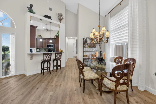 a dining room filled chandelier and wooden floor