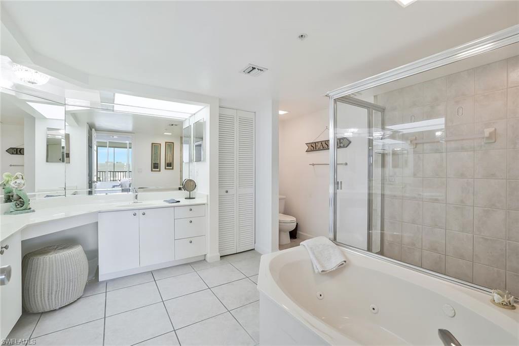 25 Bluebill Avenue, Unit 1103 Naples, FL 34108 - Photo 15 of 22 a bathroom with a granite countertop sink a toilet and shower