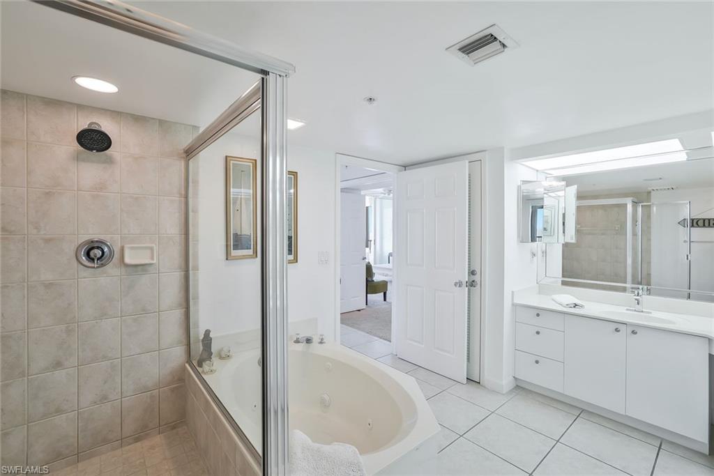 25 Bluebill Avenue, Unit 1103 Naples, FL 34108 - Photo 16 of 22 a bathroom with a tub sink and mirror