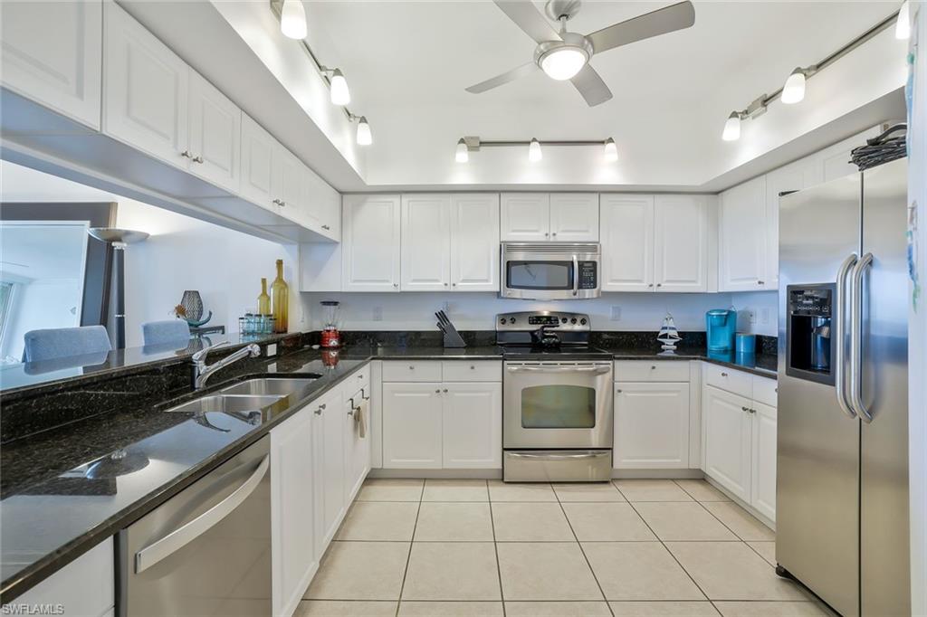 25 Bluebill Avenue, Unit 1103 Naples, FL 34108 - Photo 8 of 22 a kitchen with stainless steel appliances granite countertop a sink and cabinets