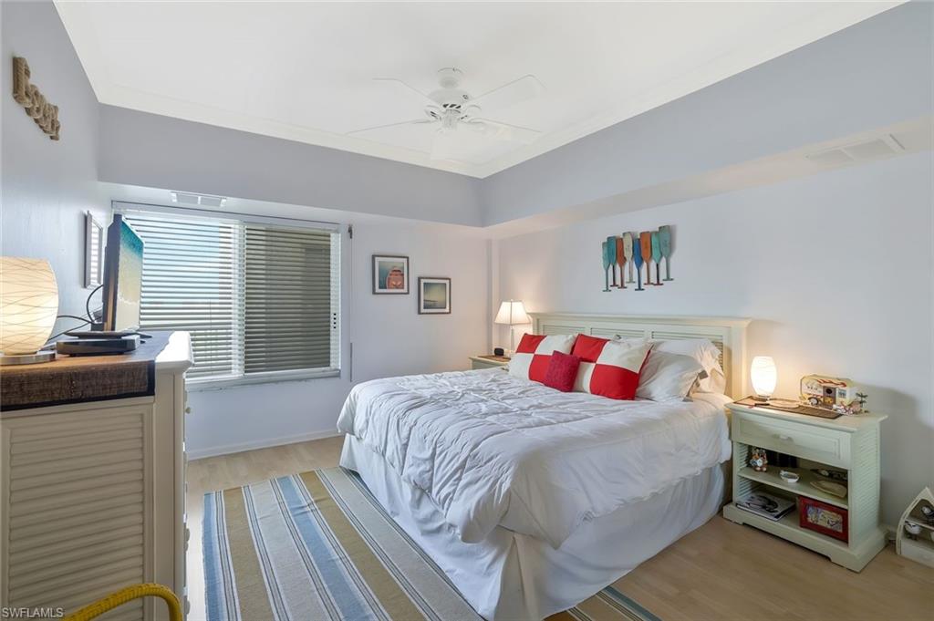 25 Bluebill Avenue, Unit 1103 Naples, FL 34108 - Photo 10 of 22 a bedroom with a bed and a chandelier