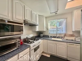 a kitchen with granite countertop a stove sink and cabinets