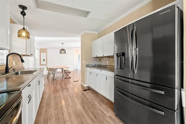 a kitchen with stainless steel appliances a refrigerator sink and cabinets