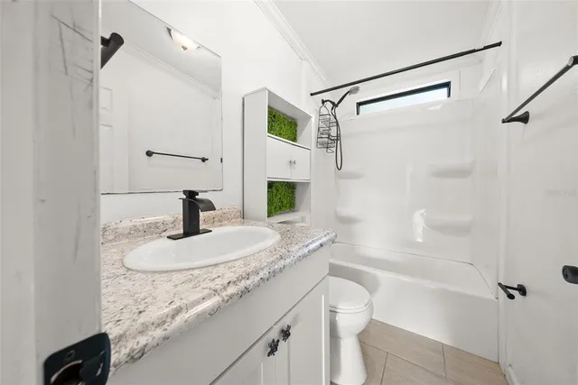 a bathroom with a granite countertop sink a toilet and shower