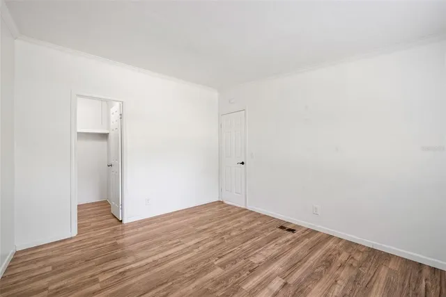 a view of empty room with wooden floor