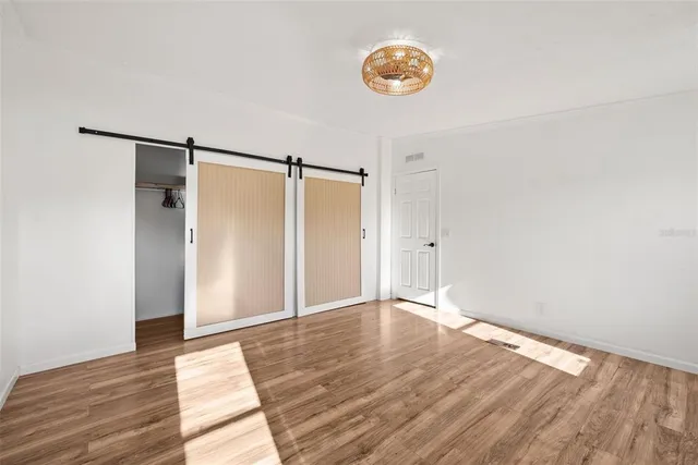 a view of an empty room with wooden floor