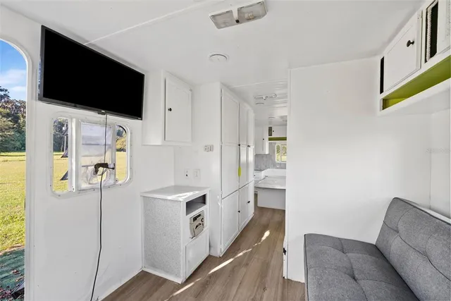 a kitchen with stainless steel appliances a refrigerator a stove a microwave and a dining table with wooden floor