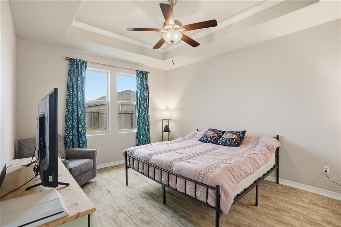 2685 Westeros Street Corpus Christi, TX 78415 - Photo 12 of 24 a bedroom with a bed a couch and a large window with wooden floor