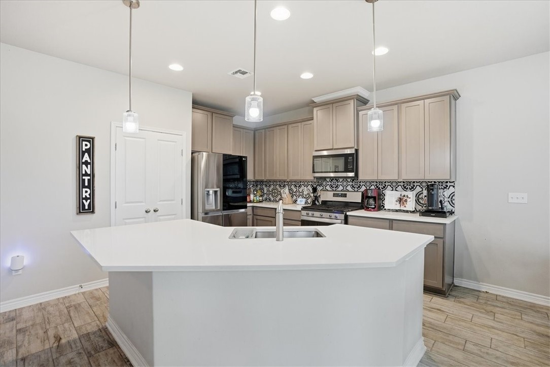 2685 Westeros Street Corpus Christi, TX 78415 - Photo 6 of 24 a large kitchen with kitchen island a sink stainless steel appliances and cabinets