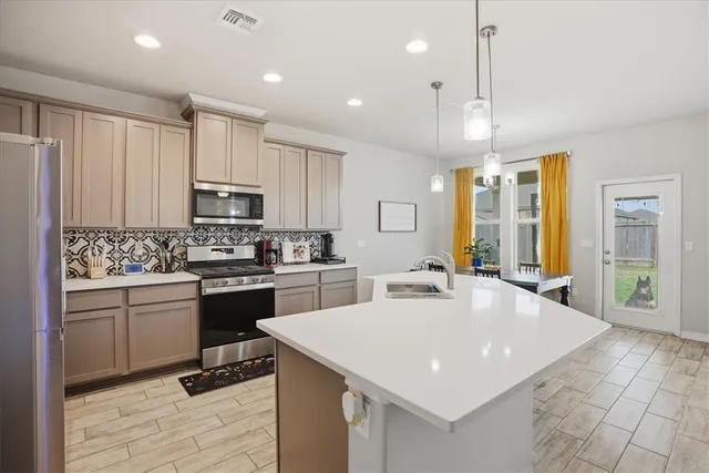 a kitchen with kitchen island granite countertop a stove a sink a oven a dining table and chairs