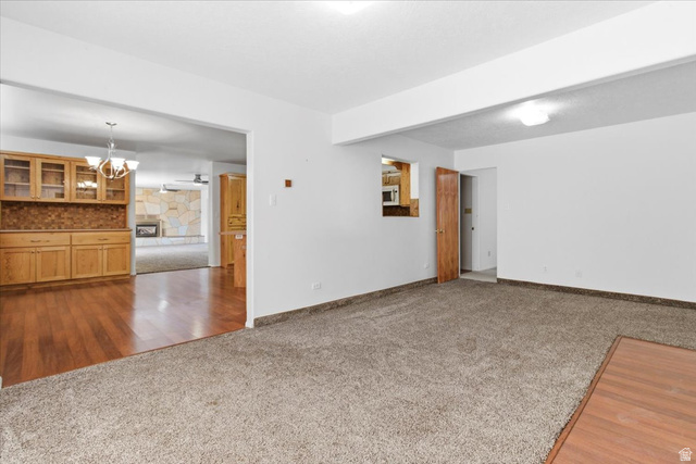 217 East 400 South Spring City, UT 84662 - Photo 3 of 71 Spare room with dark carpet, dark wood-style floors, hanging lights, and a fireplace