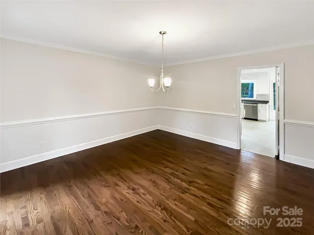 a view of a room with wooden floor and white walls
