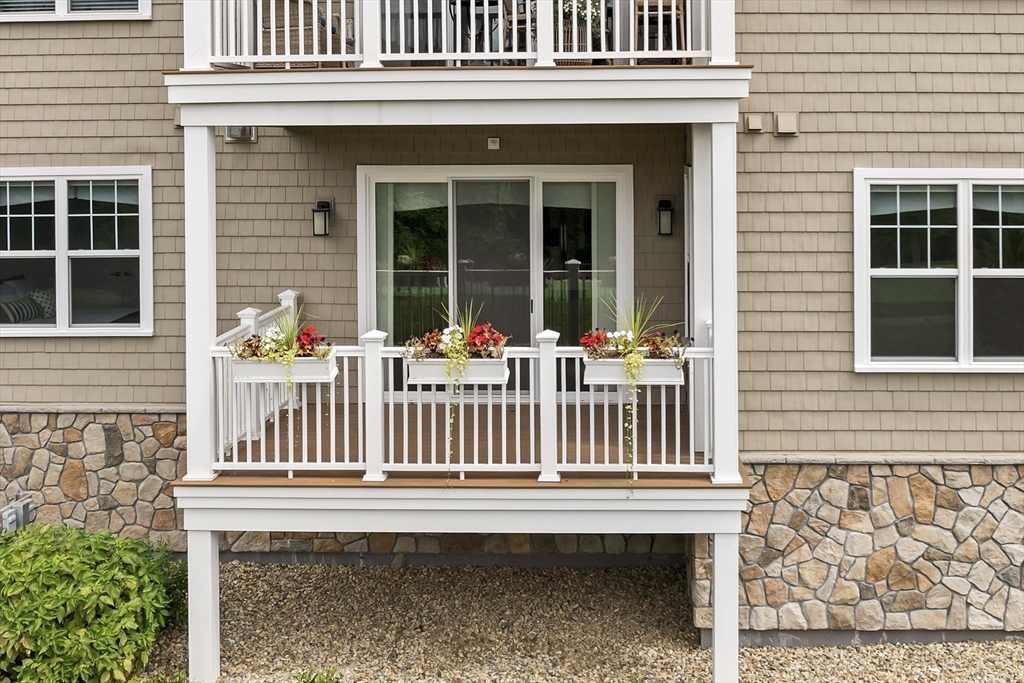 7 Longview Drive, Unit 105 Atkinson, NH 03811 - Photo 25 of 30 a porch with a bench next to a yard