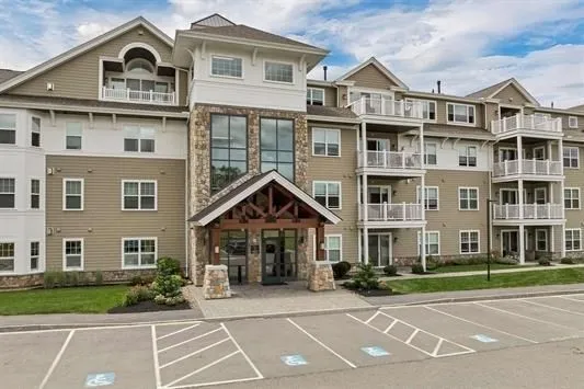 a view of a big house with a big yard and large trees