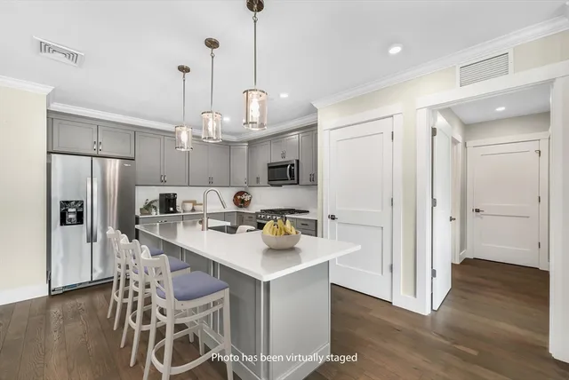 a kitchen with stainless steel appliances a refrigerator and a chandelier