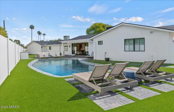 a view of a backyard with table and chairs potted plants and a palm tree