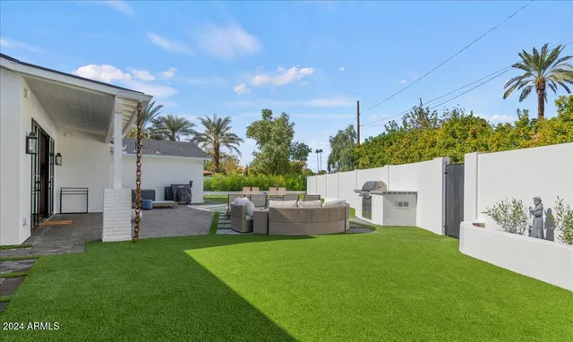 a view of a patio with couches table and chairs and potted plants