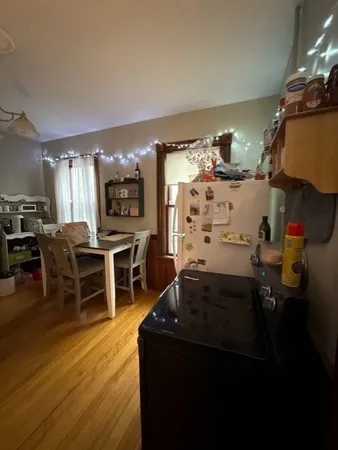 a living room with stainless steel appliances kitchen island granite countertop furniture a rug and a large window
