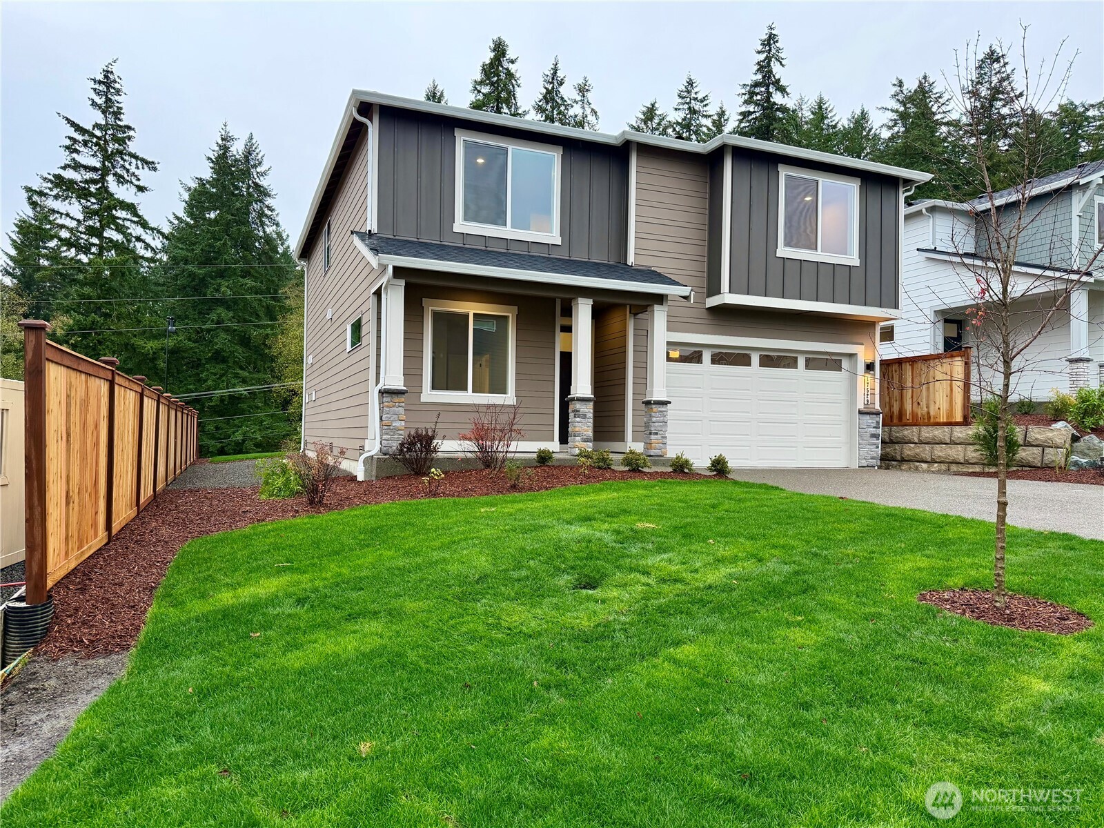 17529 Northeast Midnight Sun Loop Poulsbo, WA 98370 - Photo 2 of 36 a front view of a house with a yard and garage