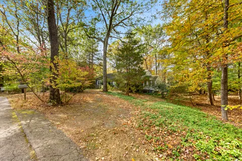 a view of a yard with trees in front of the house