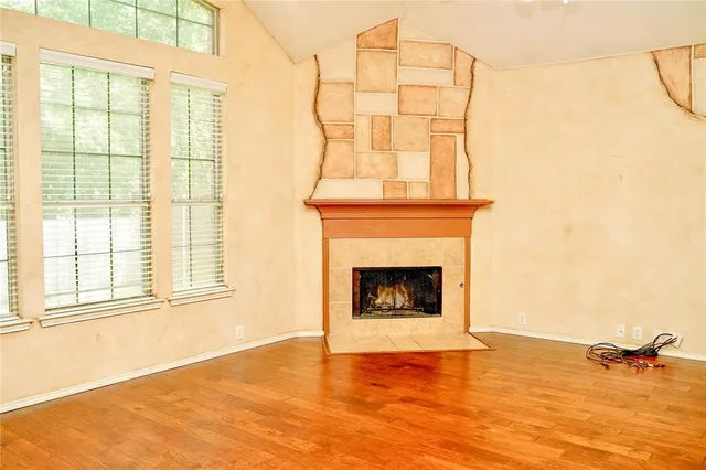 a view of an empty room with a fireplace and a window