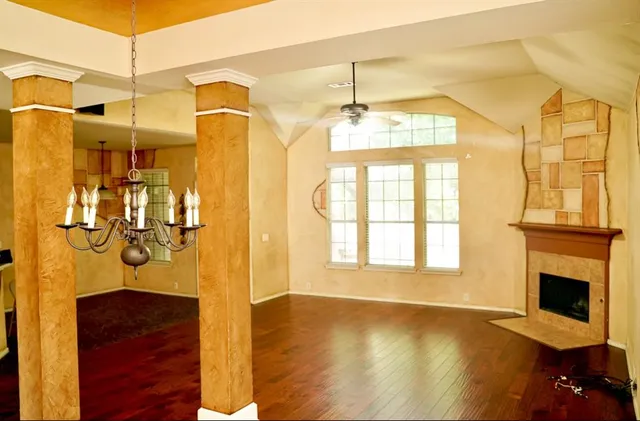 a view of a living room with a fireplace and wooden floor