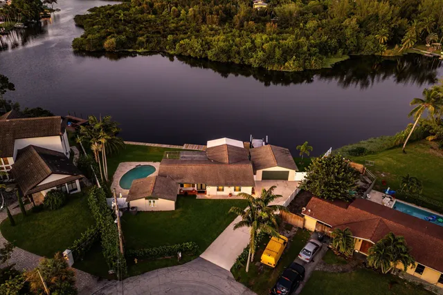 an aerial view of a house with a yard and lake view