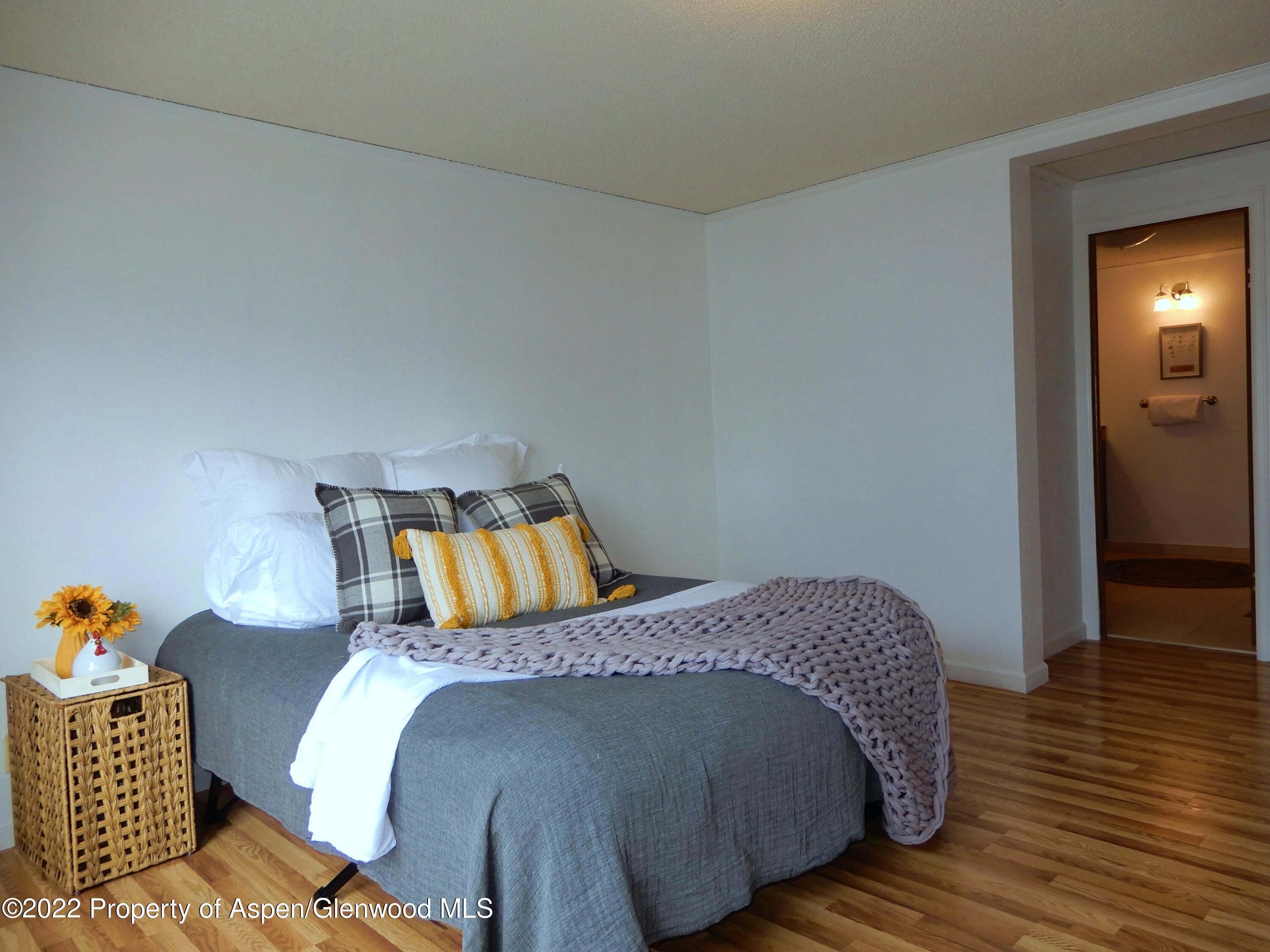 1110 Arnold Court Rifle, CO 81650 - Photo 19 of 23 a bed sitting in a bedroom next to a window and wooden floor