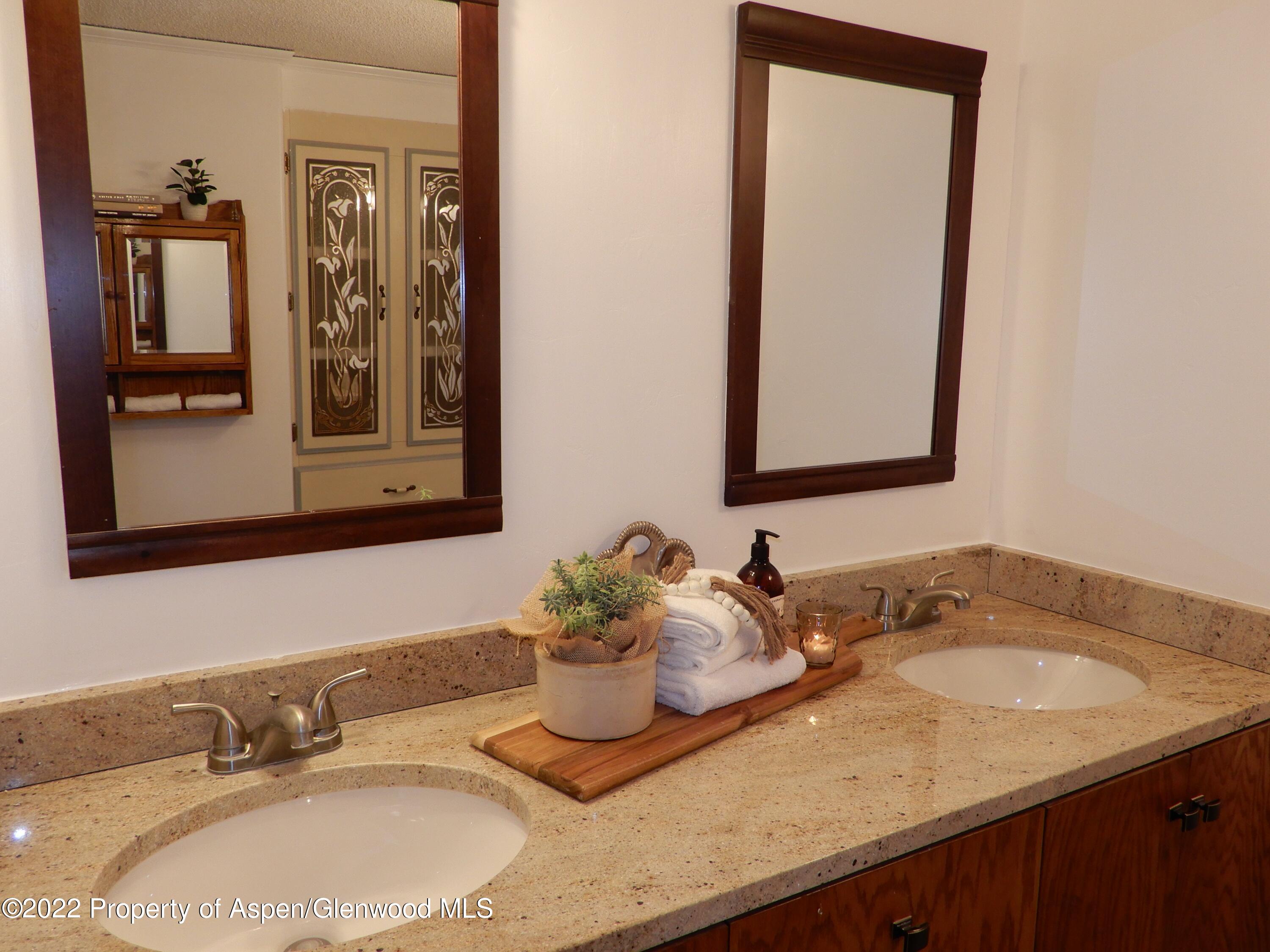1110 Arnold Court Rifle, CO 81650 - Photo 20 of 23 a bathroom with a granite countertop sink and a mirror