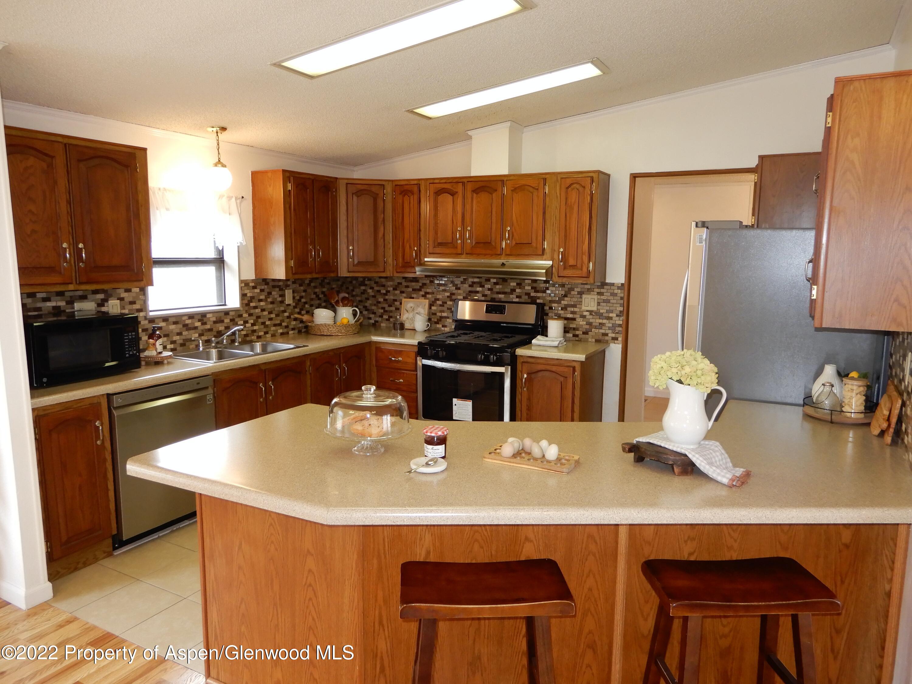 1110 Arnold Court Rifle, CO 81650 - Photo 7 of 23 a kitchen with a sink a stove and chairs