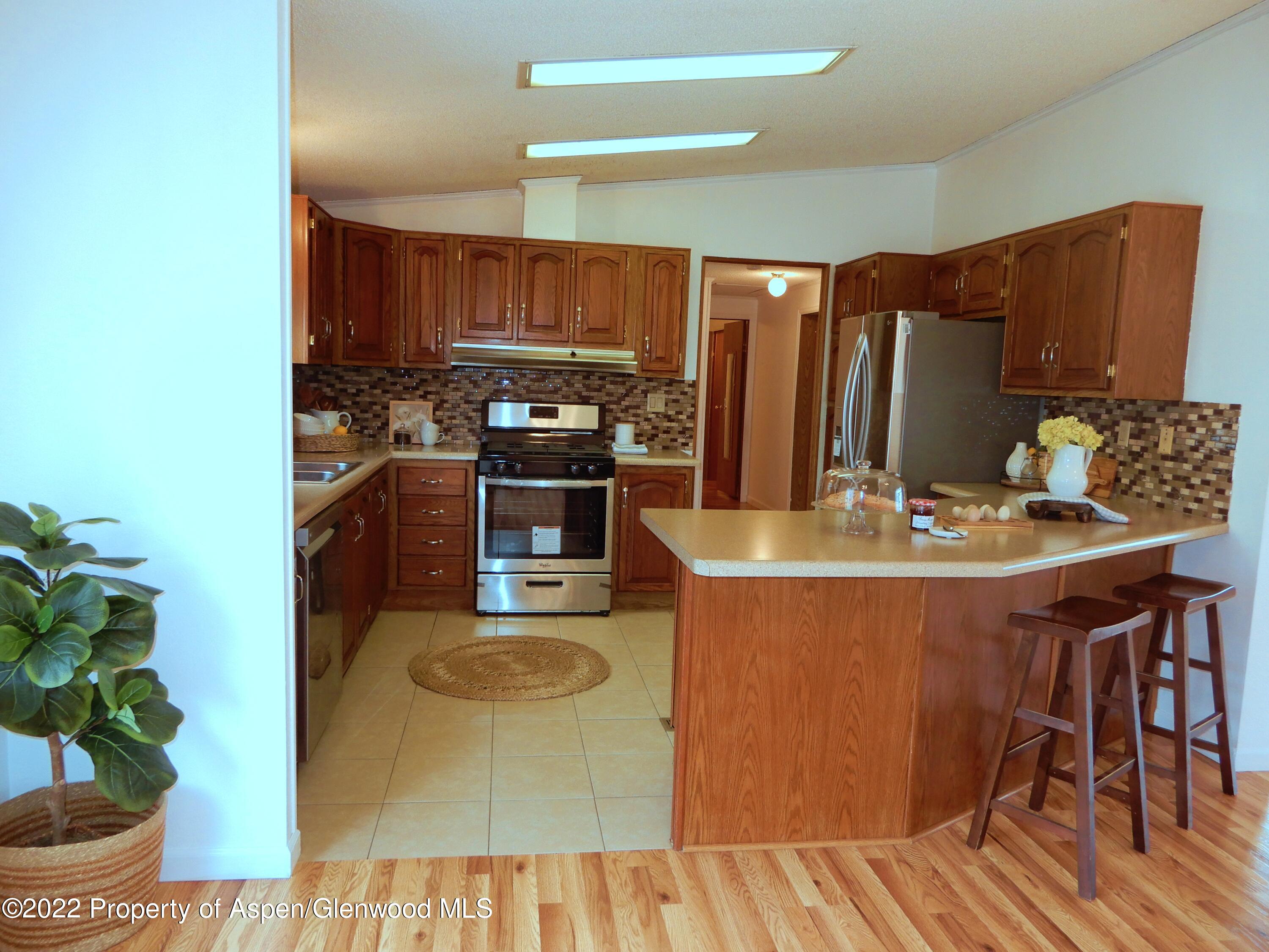 1110 Arnold Court Rifle, CO 81650 - Photo 8 of 23 a kitchen with stainless steel appliances granite countertop a sink and a refrigerator