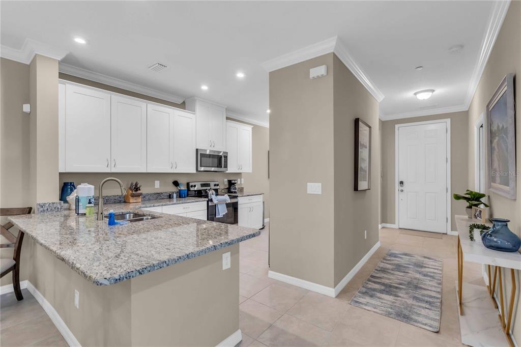 12413 Osorio Court, Unit 101 Sarasota, FL 34238 - Photo 11 of 46 a kitchen with stainless steel appliances granite countertop a refrigerator and a sink